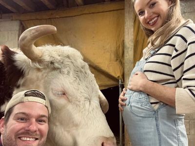 Kassandra Clementi is standing showing her baby bump, while Mike is right in front of her and Dan McKernan is taking the picture.